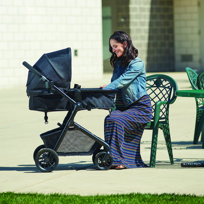Evenflo Pivot Modular Travel System with SafeMax Car Seat, stroller with car seat attached, featuring adjustable handle and storage basket.